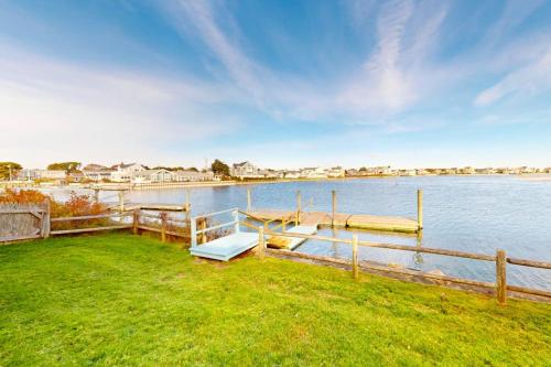 a dock with a bench next to a body of water at West Dennis Dockside in West Dennis