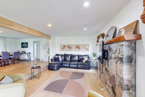 a living room with a couch and a stone fireplace at Minutes from it All in Petoskey