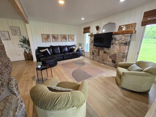 a living room with couches and a stone fireplace at Minutes from it All in Petoskey