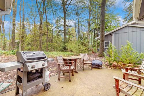 a grill and a table and chairs in a backyard at Lake Michigan Adventures in Lakeside