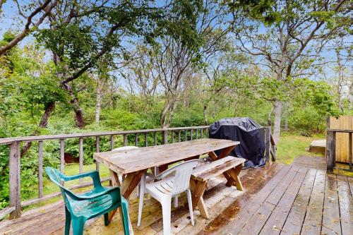 a wooden table and chairs on a wooden deck at Escape in Dennis in Dennis