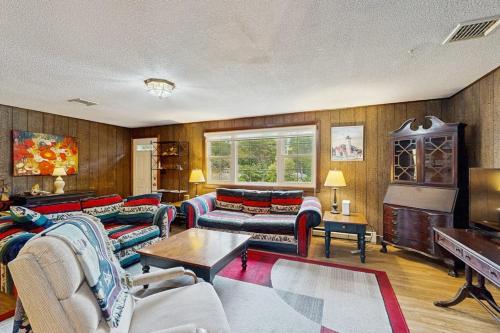 a living room with couches and a piano at The Rootskeller in Oak Bluffs