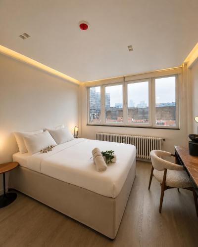 a bedroom with a large white bed and a desk at Centerstay Brussels in Brussels