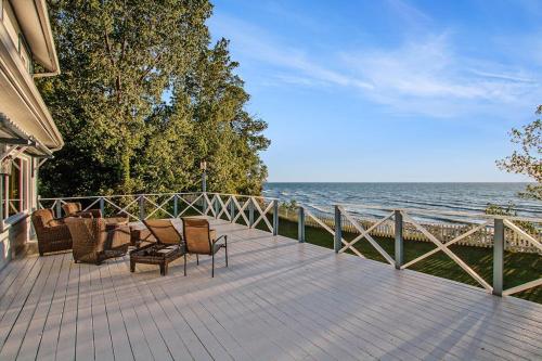 a wooden deck with chairs and a view of the ocean at Lake Michigan Retreat- Upper Duplex in Benton Harbor