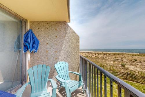 two chairs and an umbrella on a balcony with the beach at Sea Colony --- 1BB Brandywine Garden in Bethany Beach