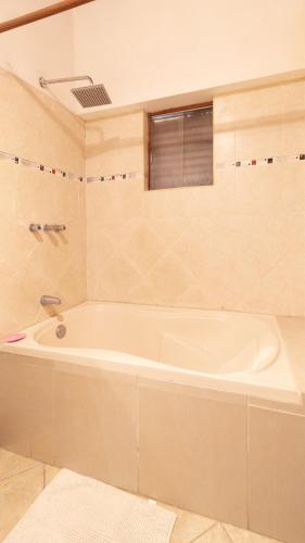 a white bath tub in a bathroom with a window at Hospedaje Chaska Pisac in Pisac