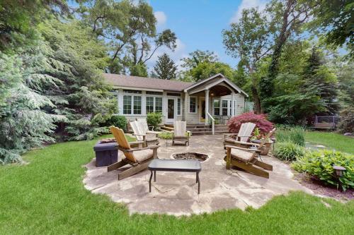 a backyard with chairs and a fire pit and a house at Happy Thoughts Cottage in New Buffalo