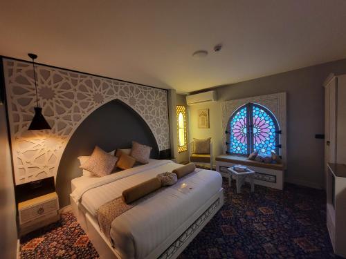 a bedroom with a bed and a stained glass window at Petra Masterpiece in Wadi Musa