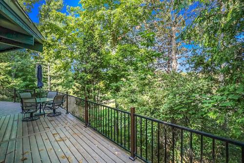 a wooden deck with a table and chairs on it at Petoskey Stone Lodge in Bellaire