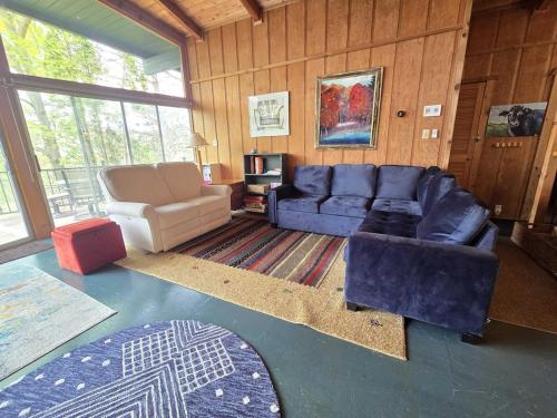 a living room with a blue couch and a chair at Petoskey Stone Lodge in Bellaire