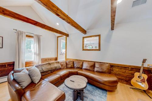 a living room with a leather couch and a guitar at Private Pocasset Getaway in Pocasset