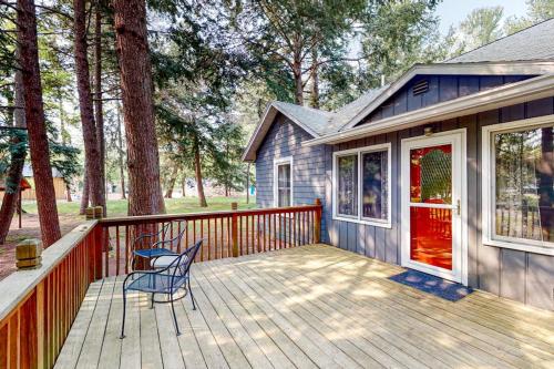 a deck with two chairs and a house at Wanderlust in Glen Arbor