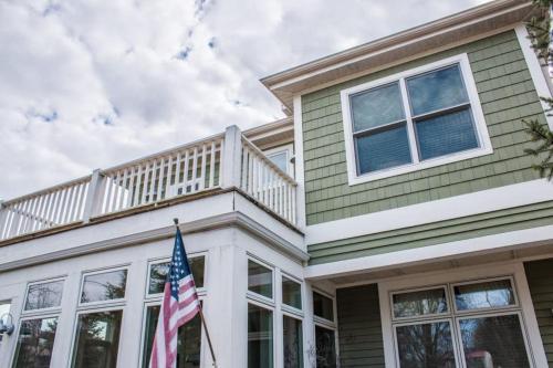 a house with a balcony and an american flag at Sunshine Villa in Union Pier