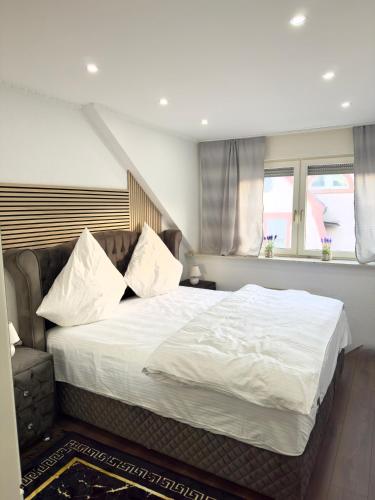 a bedroom with a large bed with white sheets and pillows at MIO plus Apartments Sulzbach in Sulzbach