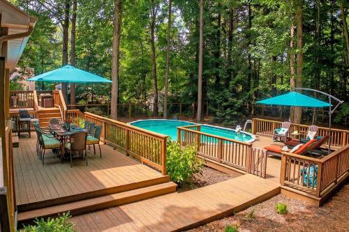 a deck with a pool and tables and umbrellas at Red Arrow Lodge in Sawyer