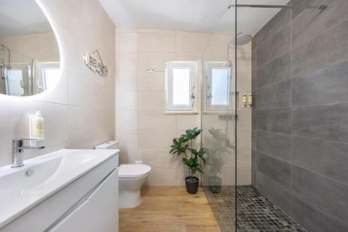 a bathroom with a toilet and a sink and a shower at SagresSeaHouse in Sagres