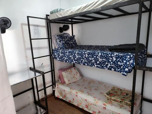 a bedroom with two bunk beds and a bench at Pousada 4 Estações in Botucatu