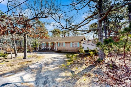 a house in the middle of a yard with trees at Eastham Glen in Eastham