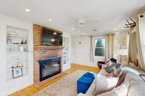 a living room with a couch and a fireplace at Coastal Hideaway in Eastham