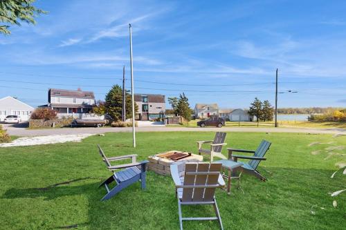 a group of chairs and a table in the grass at Coastal Hideaway in Eastham
