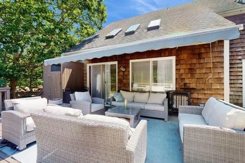 a patio with wicker chairs and tables on a house at The Big Easy in Oak Bluffs