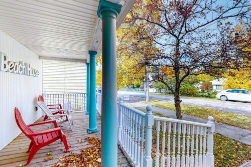 a porch with two red chairs and a pole at Beach House in Empire