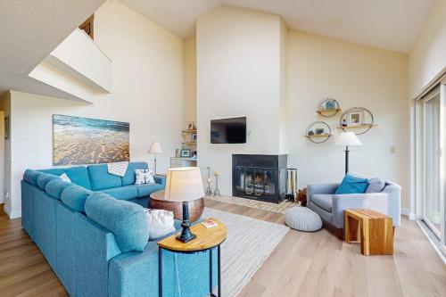 a living room with a blue couch and a fireplace at South Beach 25 in Glen Arbor