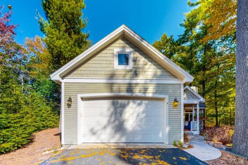 a house with a garage with a tree at Deer Park 9 in Glen Arbor