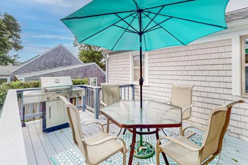a patio table and chairs with a blue umbrella at Yarmouth Bliss in Yarmouth