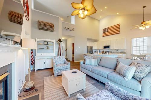 a living room with a blue couch and a kitchen at Bear Trap Dunes---26 Willow Oak Ave in Ocean View