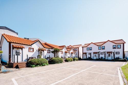 a row of houses with a parking lot at Moon Rabbit Pension in Jeju