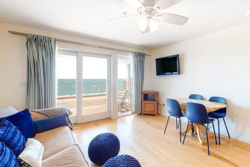 a living room with a couch and a table with chairs at Nautical Haven at Seaside in North Truro