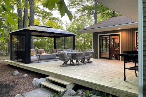 a wooden deck with a gazebo and a table and chairs at Torch Ridge Residence in Bellaire