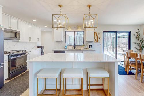 a kitchen with a large white island with bar stools at Torch Ridge Residence in Bellaire