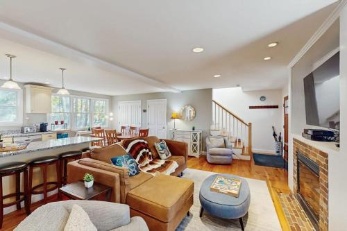 a living room with a couch and a kitchen at Wraparound Hideaway in Provincetown