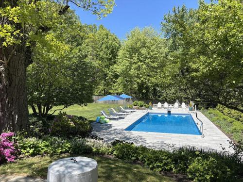 a swimming pool in a yard with chairs around it at Butterfly Pool House in Lakeside