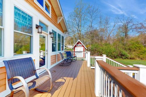 a porch with two benches and a red barn at Rise n Shine in Saugatuck