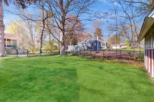 a yard with a fence in front of a house at Rise n Shine in Saugatuck