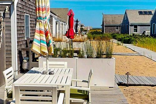 a patio with a table and an umbrella and chairs at Anchorage Escape in Truro