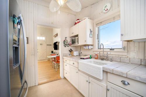 a white kitchen with a sink and a refrigerator at Lake Daze in Boyne City