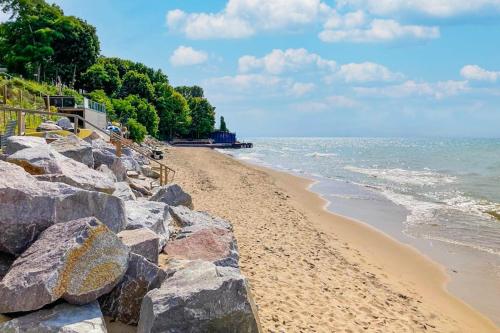 a sandy beach with rocks and the ocean at Eagles Nest in New Buffalo