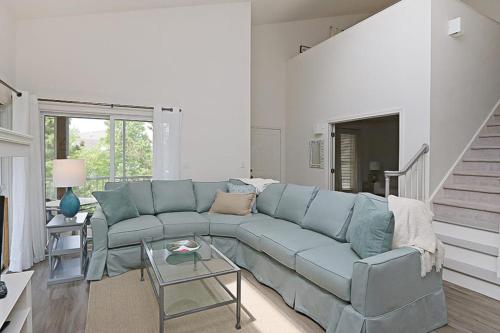 a living room with a blue couch and a staircase at Sea Colony - 55021 Pine Lake in Bethany Beach