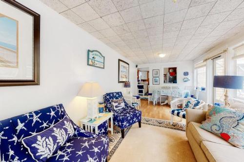 a living room with blue chairs and a couch at Paradise by Ocean Edge in Brewster