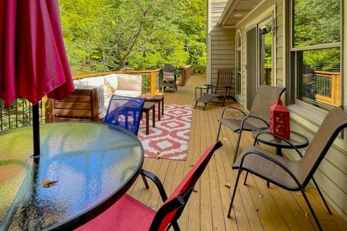 a porch with a glass table and chairs on a house at Betsie Woods in Thompsonville