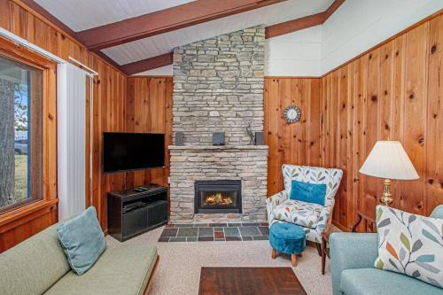 a living room with a stone fireplace and a tv at Camp David in Frankfort