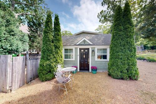 a white house with a fence and a table and chairs at Sankofa Studio in Oak Bluffs