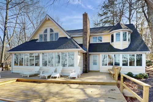 a house with a porch with white furniture on a deck at Heron Creek in Laketown Township