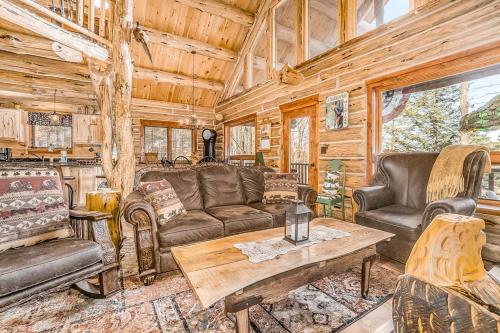a living room with leather furniture in a log cabin at Salmon Run in Thompsonville