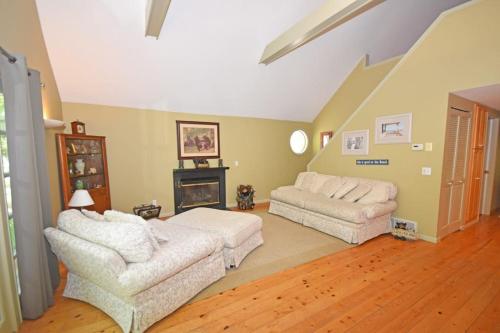 a living room with two white couches and a fireplace at Dancin' Bear in Glen Arbor