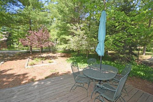 a table and chairs with an umbrella on a deck at Dancin' Bear in Glen Arbor